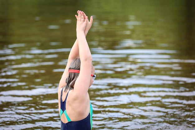 Una ragazza nuota nel fiume in una calda giornata estiva