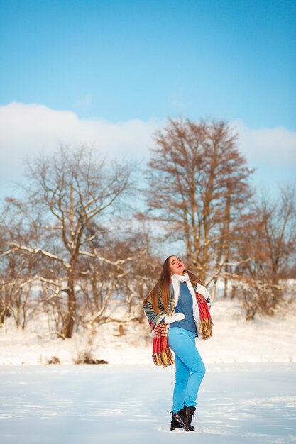 Una ragazza si trova su un lago ghiacciato in inverno e si rallegra della vita Vestiti caldi ed emozioni sincere