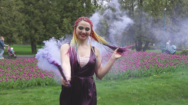 Una ragazza sorridente con trucco luminoso e trecce colorate