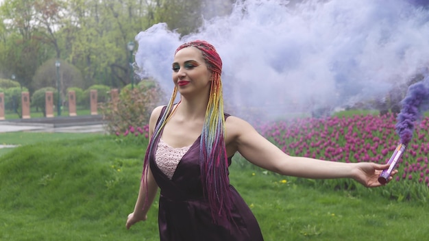 Una ragazza sorridente con trucco luminoso e trecce colorate