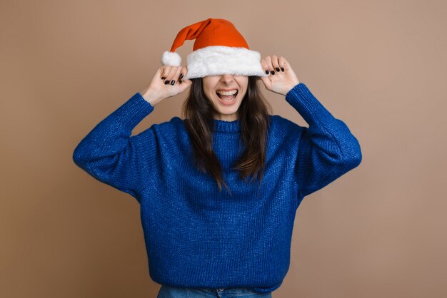 Una ragazza sorridente le tirò il cappello sugli occhi. Su uno sfondo marrone.