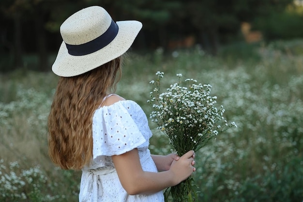 una ragazza sta con le spalle e tiene un mazzo di fiori