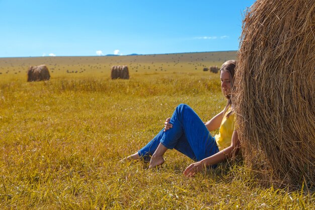 Una ragazza sta prendendo il sole nel fieno. vita del villaggio: raccolta del fieno per l'inverno. Cibo per animali.