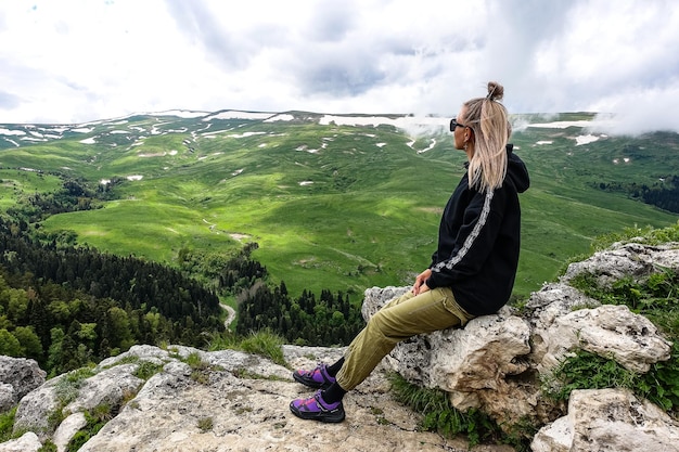 Una ragazza sullo sfondo dei prati alpini dell'altopiano LagoNaki in Adygea Russia 2021