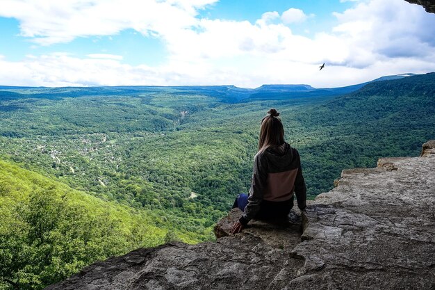 Una ragazza sullo sfondo del paesaggio delle montagne del Caucaso Eagle oscilla Mezmai