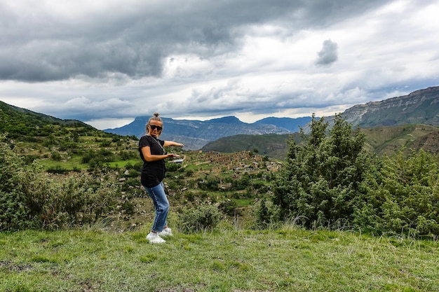 Una ragazza sullo sfondo del villaggio di Kurib nelle montagne del Caucaso sulla cima di una scogliera Daghestan Russia Giugno 2021