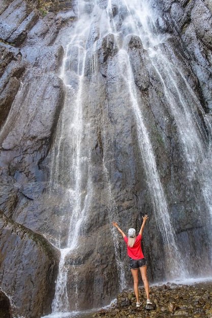 Una ragazza sullo sfondo della cascata AbaiSu Caucaso settentrionale KabardinoBalkaria giugno 2021