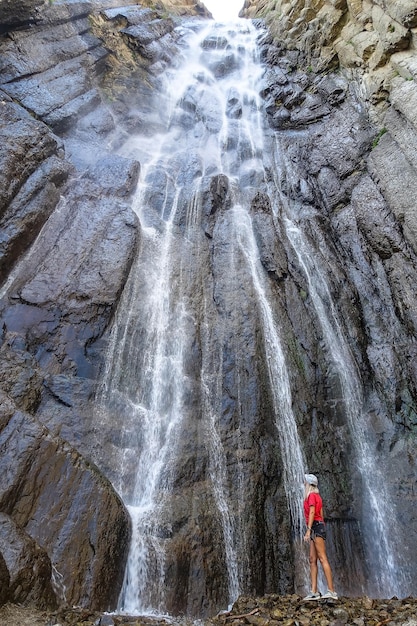 Una ragazza sullo sfondo della cascata AbaiSu Caucaso settentrionale KabardinoBalkaria giugno 2021