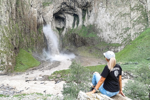 Una ragazza sullo sfondo della cascata KarakayaSu nel territorio di KabardinoBalkaria