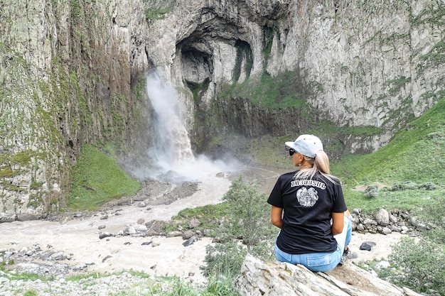 Una ragazza sullo sfondo della cascata TuzlukShapa sul territorio di KabardinoBalkaria Caucaso Russia