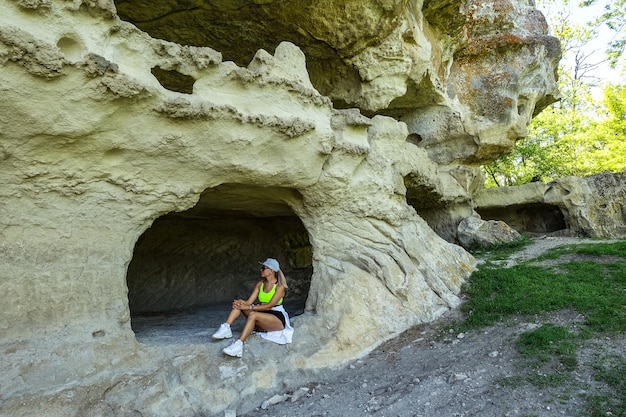 Una ragazza sullo sfondo della grotta della città di TepeKermen a Bakhchisarai Crimea Russia