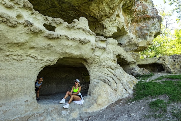 Una ragazza sullo sfondo della grotta della città di TepeKermen a Bakhchisarai Crimea Russia