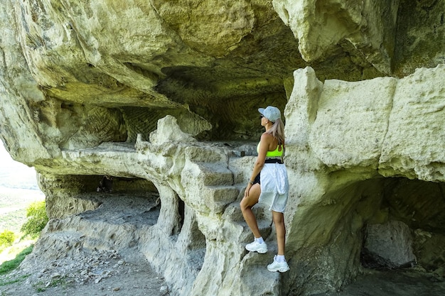 Una ragazza sullo sfondo della grotta della città di TepeKermen a Bakhchisarai Crimea Russia