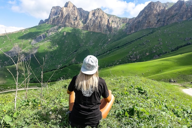 Una ragazza sullo sfondo di un paesaggio verde del passo Aktoprak nel Caucaso Russia giugno 2021