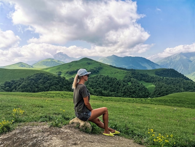 Una ragazza sullo sfondo di un paesaggio verde del passo Aktoprak nel Caucaso Russia giugno 2021