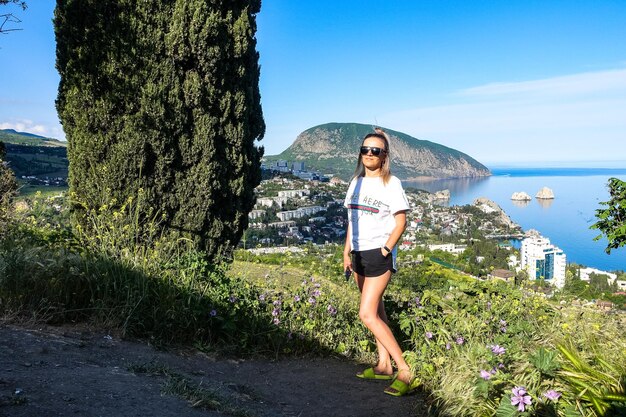 Una ragazza sullo sfondo ha una vista del monte AyuDag e della città di Gurzuf dal ponte di osservazione maggio 2021