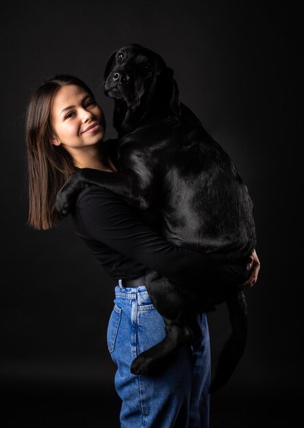 Una ragazza tiene in braccio un cane Labrador Retriever