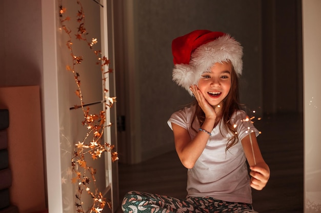 una ragazza tiene le stelle filanti nel cappello di Babbo Natale il miracolo di natale