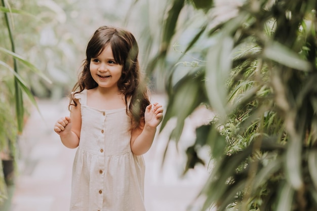 una ragazzina cammina nel giardino botanico felice bambino e palme