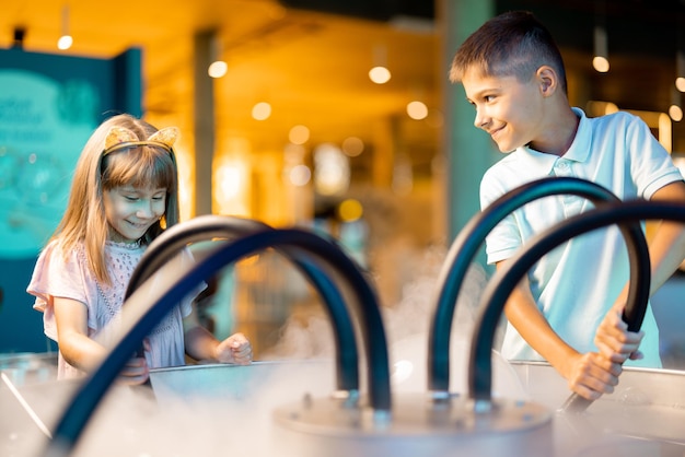 Una ragazzina e un ragazzo fanno bolle di sapone nel museo della scienza