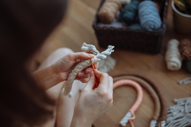 Una ragazzina tesse pannelli di macrame a casa