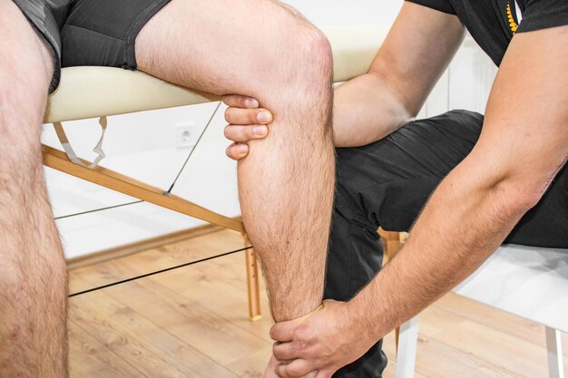 Una ripresa ravvicinata di un fisioterapeuta che aiuta un paziente con il ginocchio