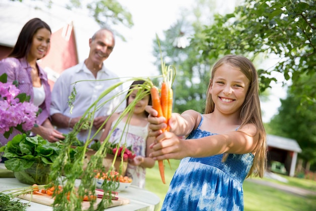 Una riunione estiva di famiglia in una fattoria Una tavola imbandita con insalate e frutta e verdura fresca I genitori