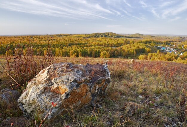 una roccia sulla collina foglie autunnali gialle sugli alberi colline della foresta la linea dell'orizzonte autunno horizon