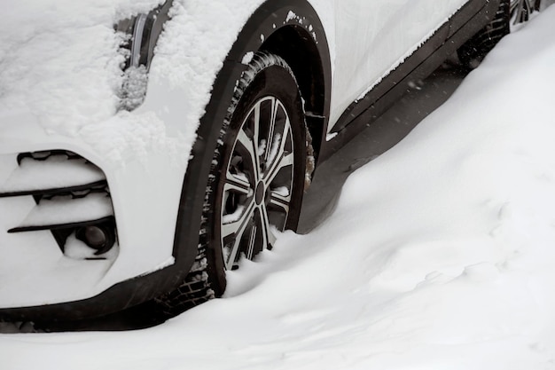 Una ruota di automobile in un cumulo di neve in una fredda giornata invernale