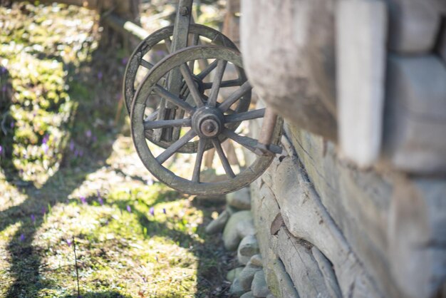 Una ruota di legno pende da un muro in una zona rurale.