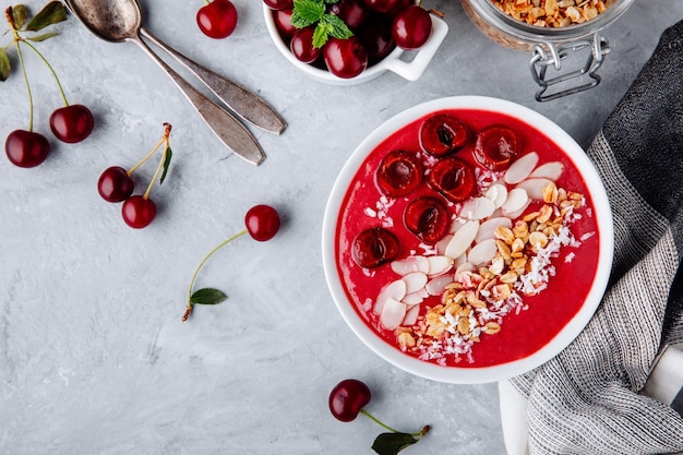 Una sana ciotola per la colazione Frullato di ciliegie rosse con muesli, mandorle, cocco e frutti di bosco freschi