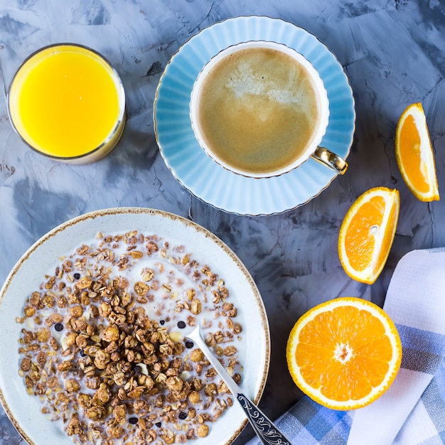 Una sana colazione di muesli al cioccolato con caffè, arance e succo