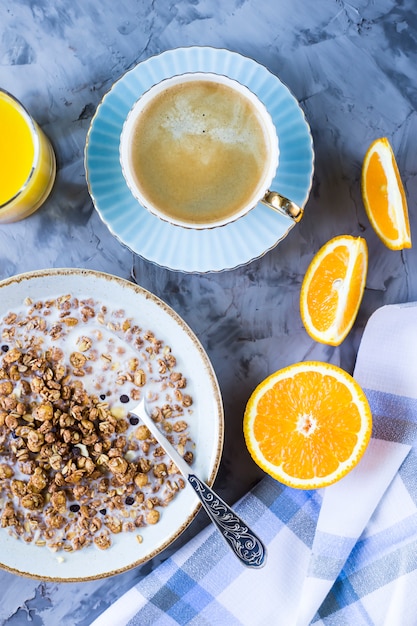 Una sana colazione di muesli al cioccolato con caffè, arance e succo