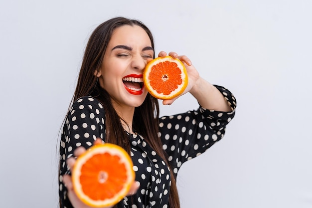 Una sana dieta alimentare Bella ragazza in buona salute con fette di arance Bellezza moda giovane donna gioca con la frutta Vegetariano