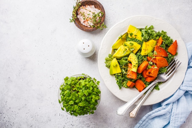 Una sana insalata di cavolo verde con avocado e patate dolci al forno