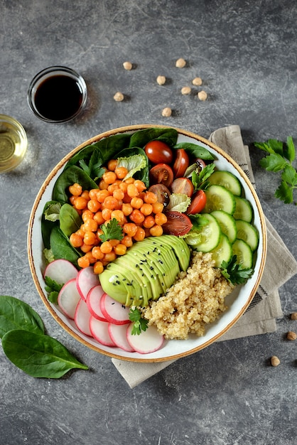 Una sana insalata vegetariana con ceci, quinoa, cetrioli, ravanelli e avocado