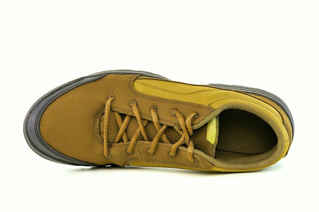 Una scarpa da trekking in tessuto giallo a buon mercato a destra isolata su sfondo bianco