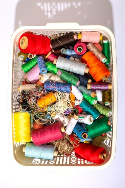 Una scatola con monete multicolori di diversi fili vista dall'alto