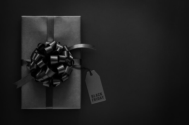 Una scatola regalo con nastro che ha l'etichetta del prezzo con la parola su sfondo nero concetto di venerdì nero