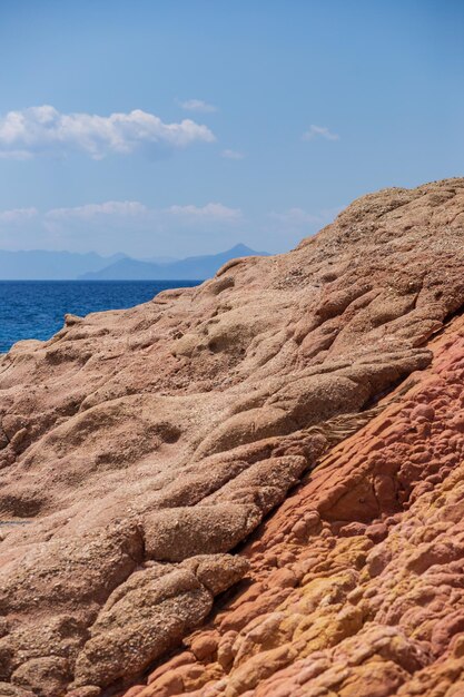 Una scogliera rocciosa con un cielo blu e il mare sullo sfondo