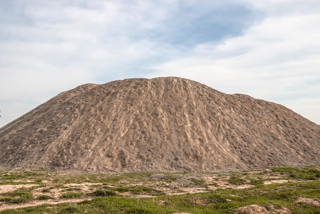 Una scorta di materiali da costruzione inerti Un grande mucchio di sabbia e ghiaia Foto ad alta risoluzione