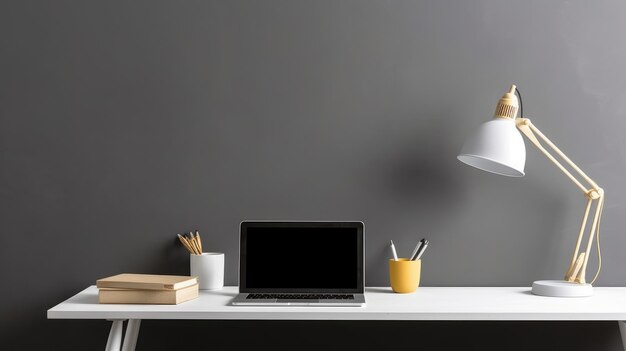 Una scrivania con sopra una lampada e un computer portatile