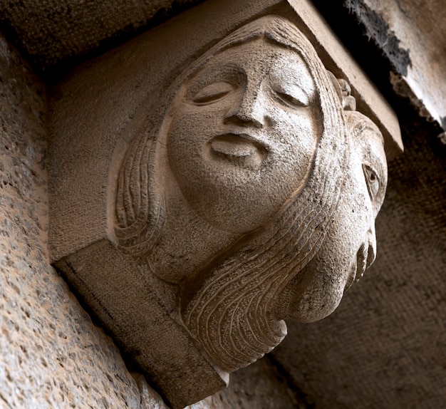 Una scultura in pietra di una donna con un volto sopra