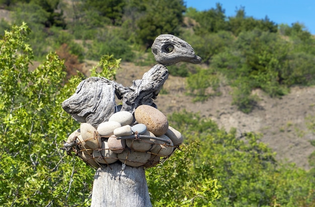 Una scultura in pietra e legno a forma di uccello in un nido.