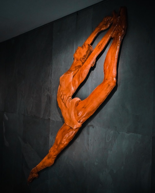 Una scultura rossa di una donna appesa a un muro