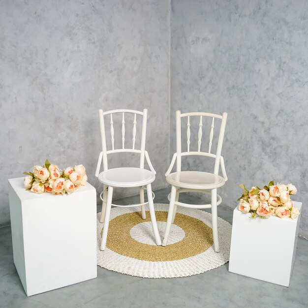 Una sedia bianca con sopra una composizione floreale