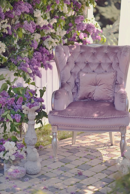 Una sedia viola si trova di fronte a un balcone con fiori viola.