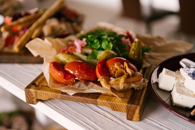 Una serie di snack italiani per un buffet Una varietà di formaggi salumi bruschette cetrioli sottaceto pomodori su sfondo di legno