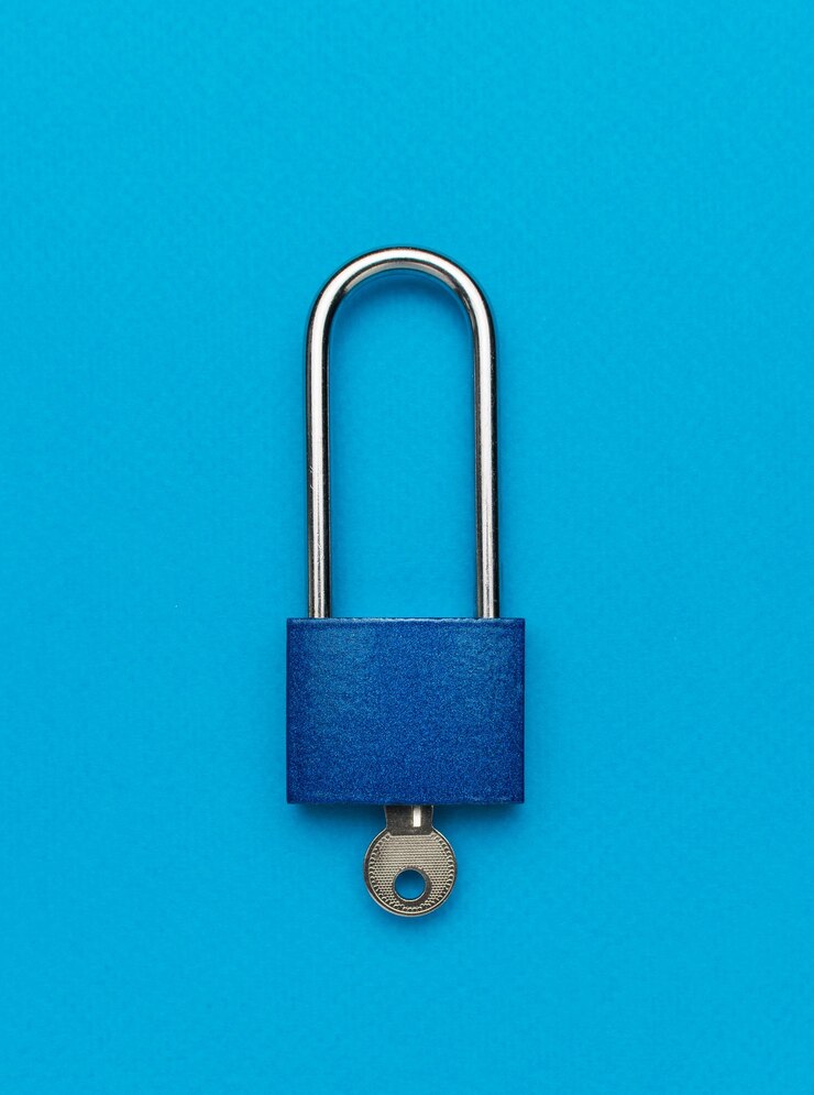 Una serratura di metallo chiusa con una chiave su uno sfondo blu Il concetto di protezione