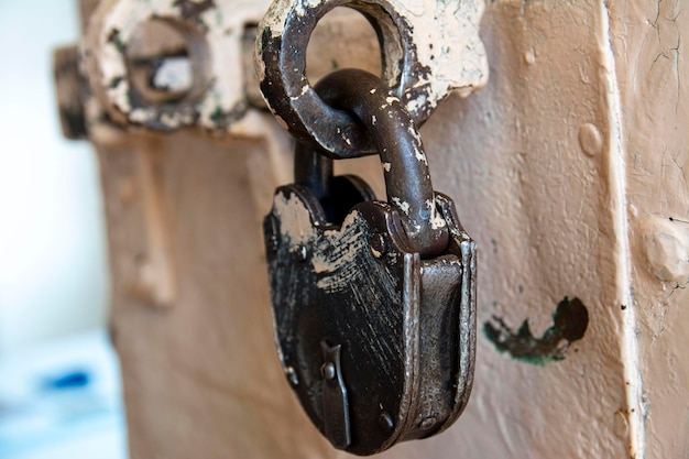 Una serratura massiccia imbottita è appesa alla porta. vecchia vernice e metallo sbiaditi, leggermente scuriti dal tempo, bullone pesante.